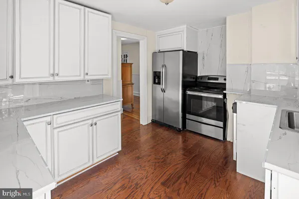 a kitchen with granite countertop white cabinets and stainless steel appliances