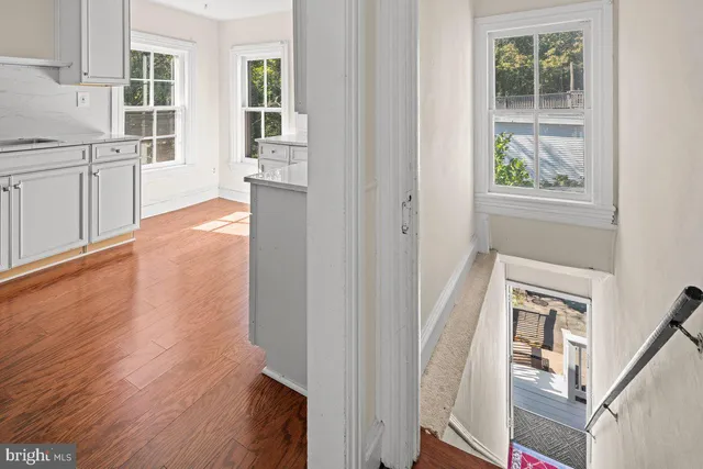 a view of a kitchen with wooden floor and windows