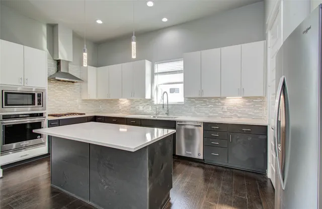 a kitchen with kitchen island granite countertop a sink stove and refrigerator