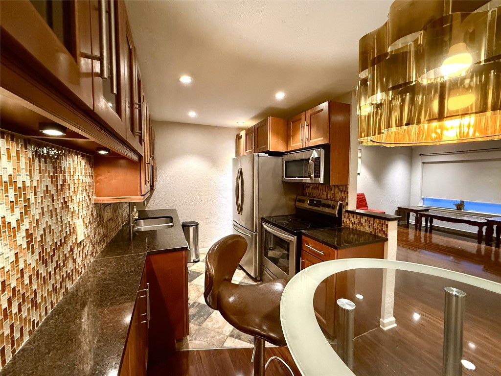 606 Marshall Street, Unit B13 Houston, TX 77006 - Photo 2 of 23 a kitchen with stainless steel appliances granite countertop a sink a stove and a refrigerator