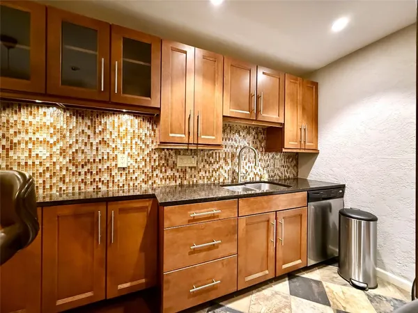 a kitchen with granite countertop wooden cabinets and sink
