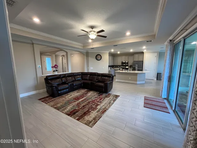 a bedroom with a bed mirror on dresser and a chandelier
