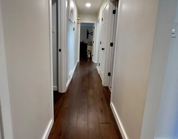 a view of a hallway with wooden floor and staircase
