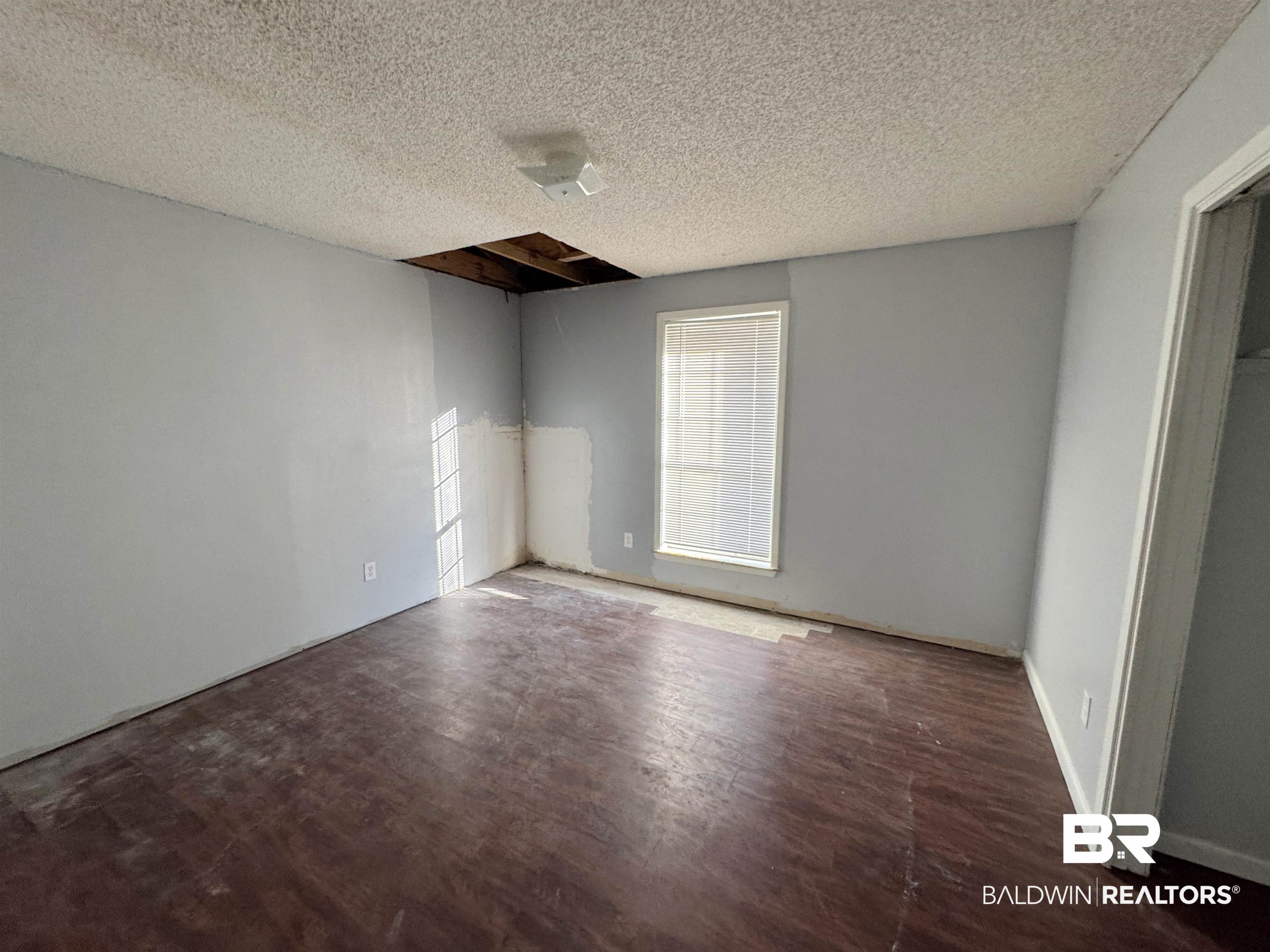 1227 Northgate Drive Atmore, AL 36502 - Photo 10 of 14 Spare room featuring dark wood-type flooring and a textured ceiling