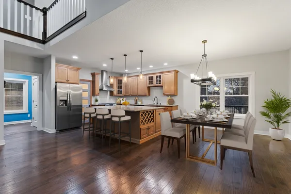 a kitchen with stainless steel appliances granite countertop a stove a sink a refrigerator and a wooden cabinets