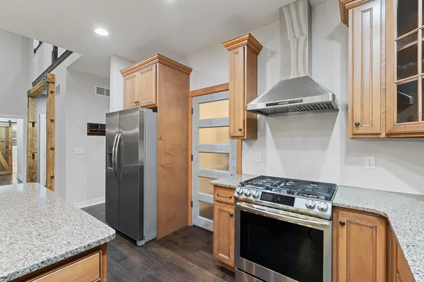 a kitchen with kitchen island a counter top space a sink refrigerator and cabinets
