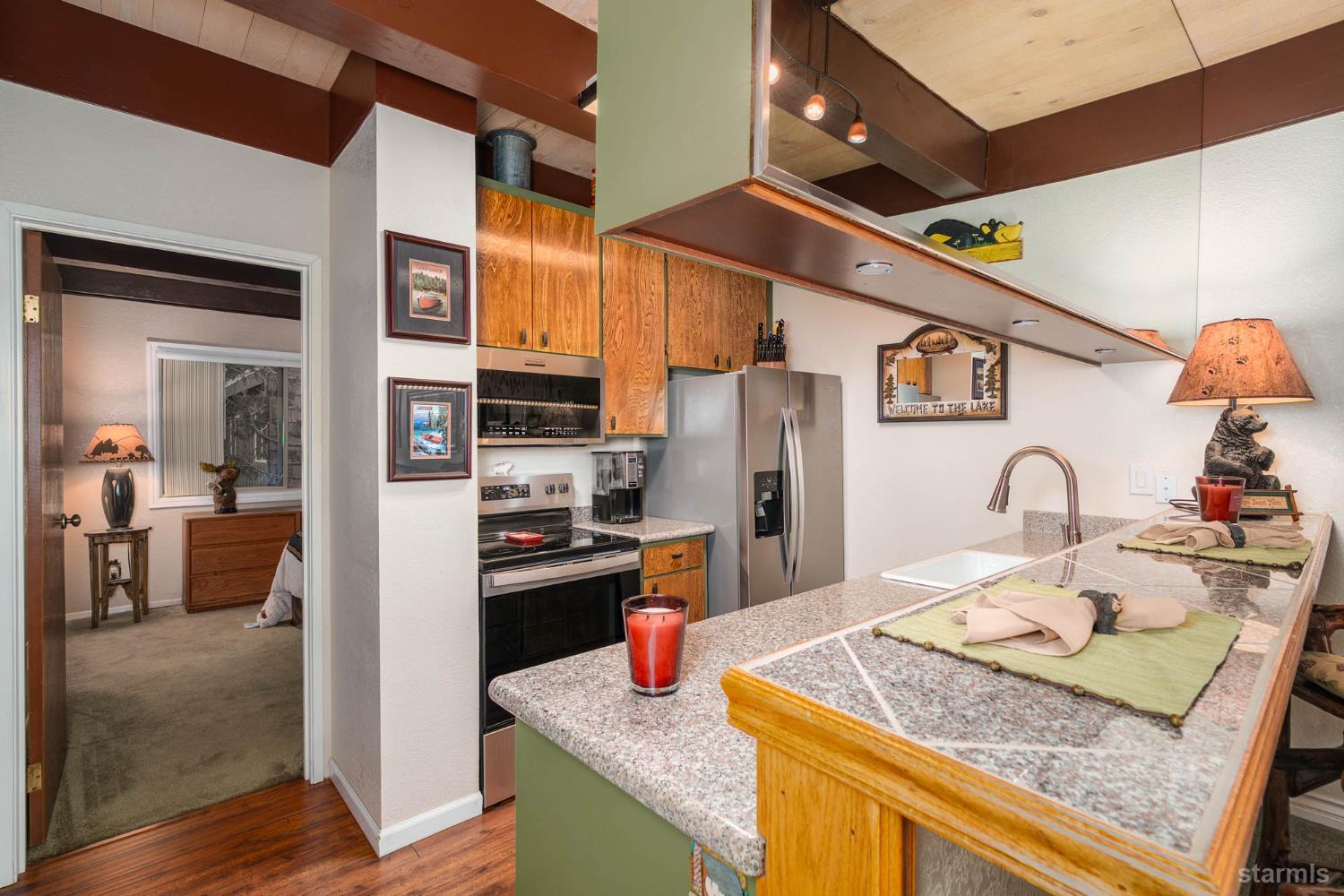 2031 Venice Drive, Unit 322 South Lake Tahoe, CA 96150 - Photo 30 of 38 a kitchen with stainless steel appliances granite countertop sink stove and refrigerator