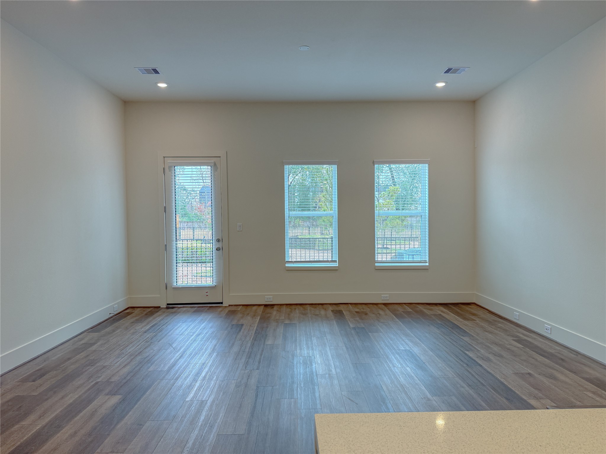 879 Rachel Street, Unit D Houston, TX 77091 - Photo 13 of 29 an empty room with wooden floor and windows