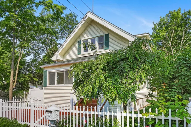 a house with a small yard and wooden fence