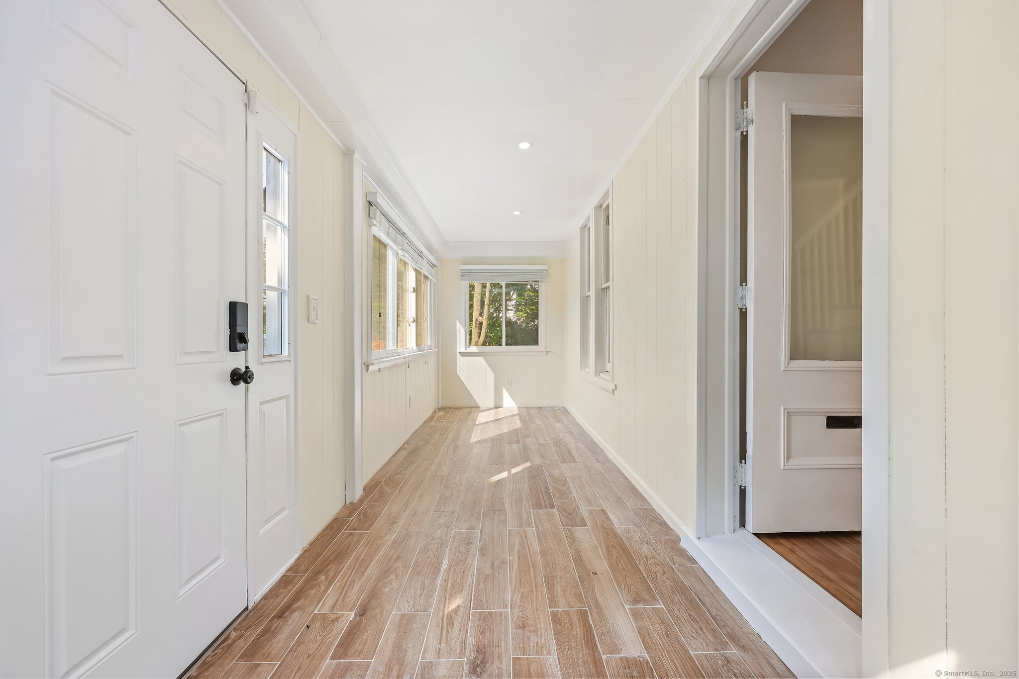 366 Suburban Avenue Fairfield, CT 06825 - Photo 4 of 34 a view of a hallway with wooden floor and a bathroom