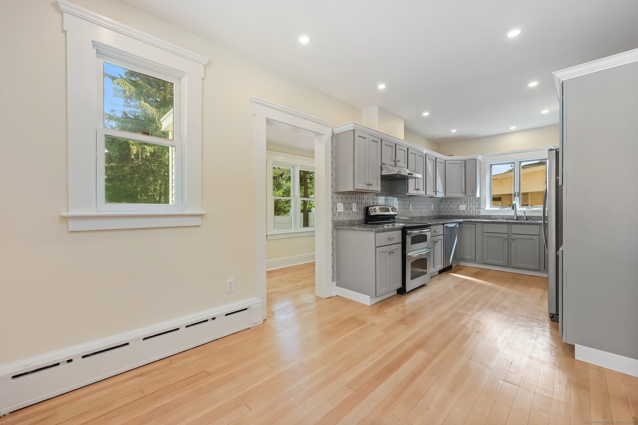 366 Suburban Avenue Fairfield, CT 06825 - Photo 9 of 34 a kitchen with stainless steel appliances granite countertop a stove top oven a sink dishwasher and a refrigerator with wooden floor