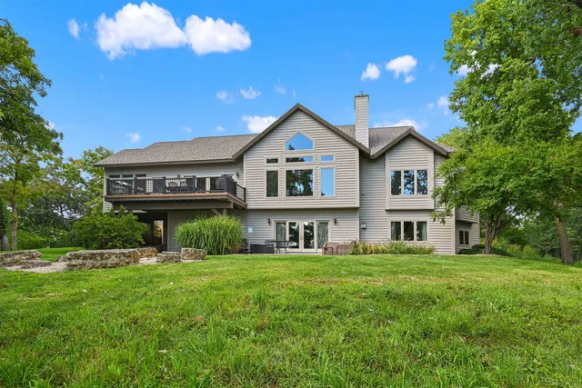 a view of a house with a big yard and large trees
