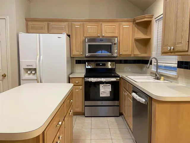 a kitchen with a sink a stove and a refrigerator