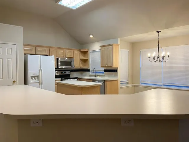 a large kitchen with kitchen island a sink stainless steel appliances and cabinets