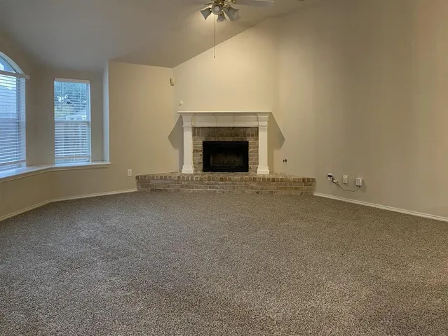 an empty room with a fireplace and window