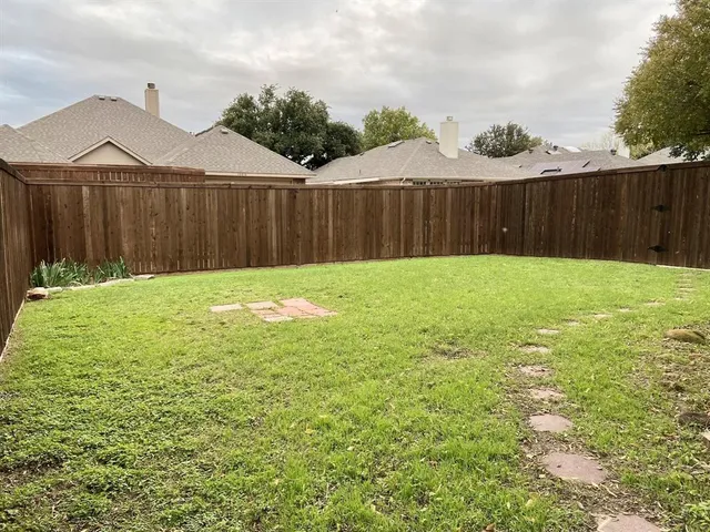 a view of garden with wooden fence
