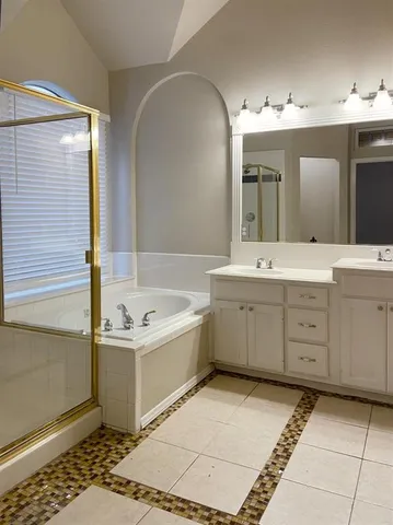 a spacious bathroom with a tub sink and mirror