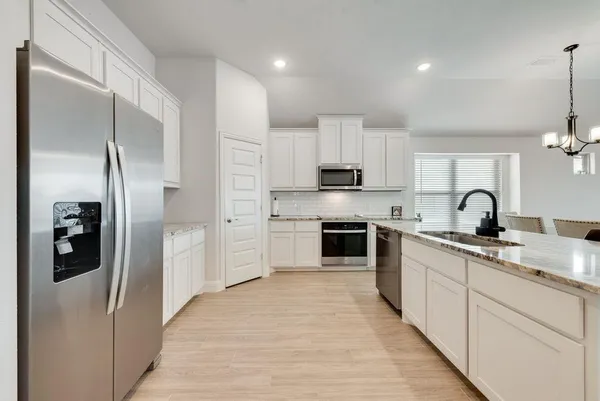 a kitchen with stainless steel appliances granite countertop a refrigerator and a sink