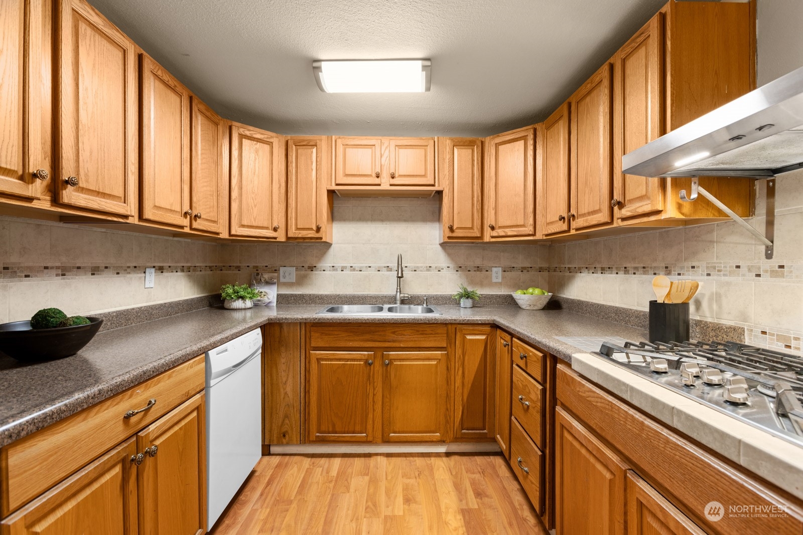 3613 Northeast 8th Street Renton, WA 98056 - Photo 12 of 31 a kitchen with stainless steel appliances granite countertop a stove a sink dishwasher and cabinets with wooden floor