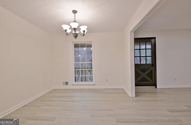 a large white kitchen with granite countertop a stove a sink and a fireplace