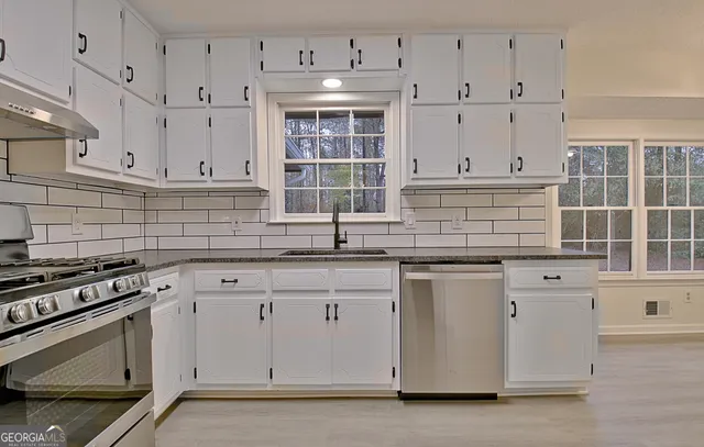 a view of a kitchen with cabinets and wooden floor