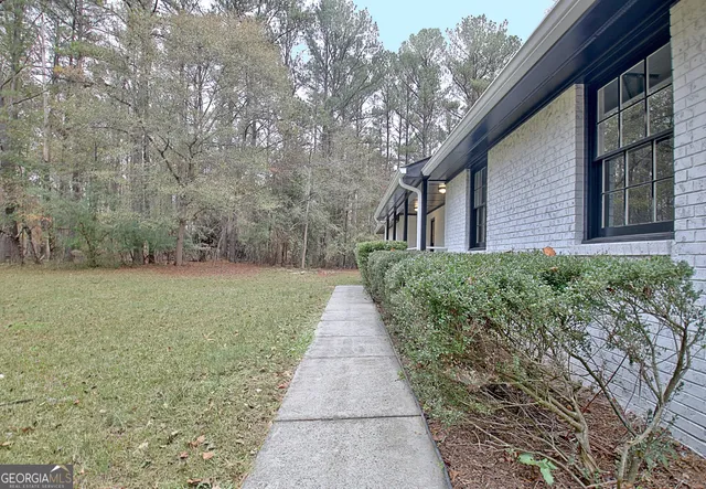 a pathway of a house with a yard