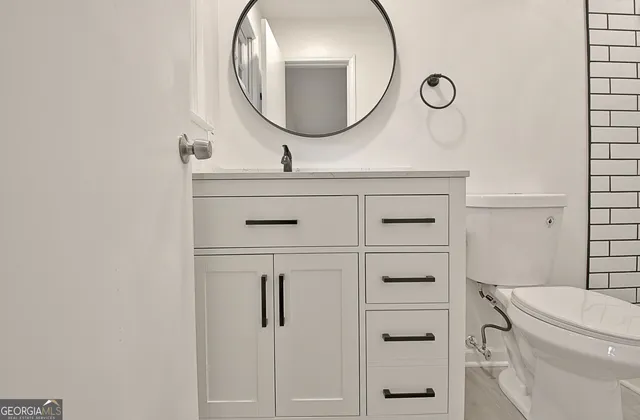 a bathroom with a toilet a sink and mirror