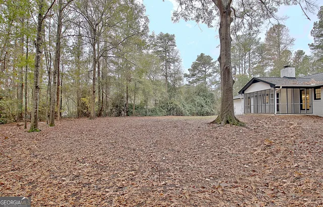 a view of a house with backyard and trees