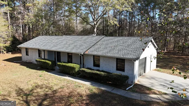 a view of a house with a yard and large tree