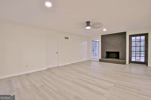 an empty room with wooden floor and fireplace