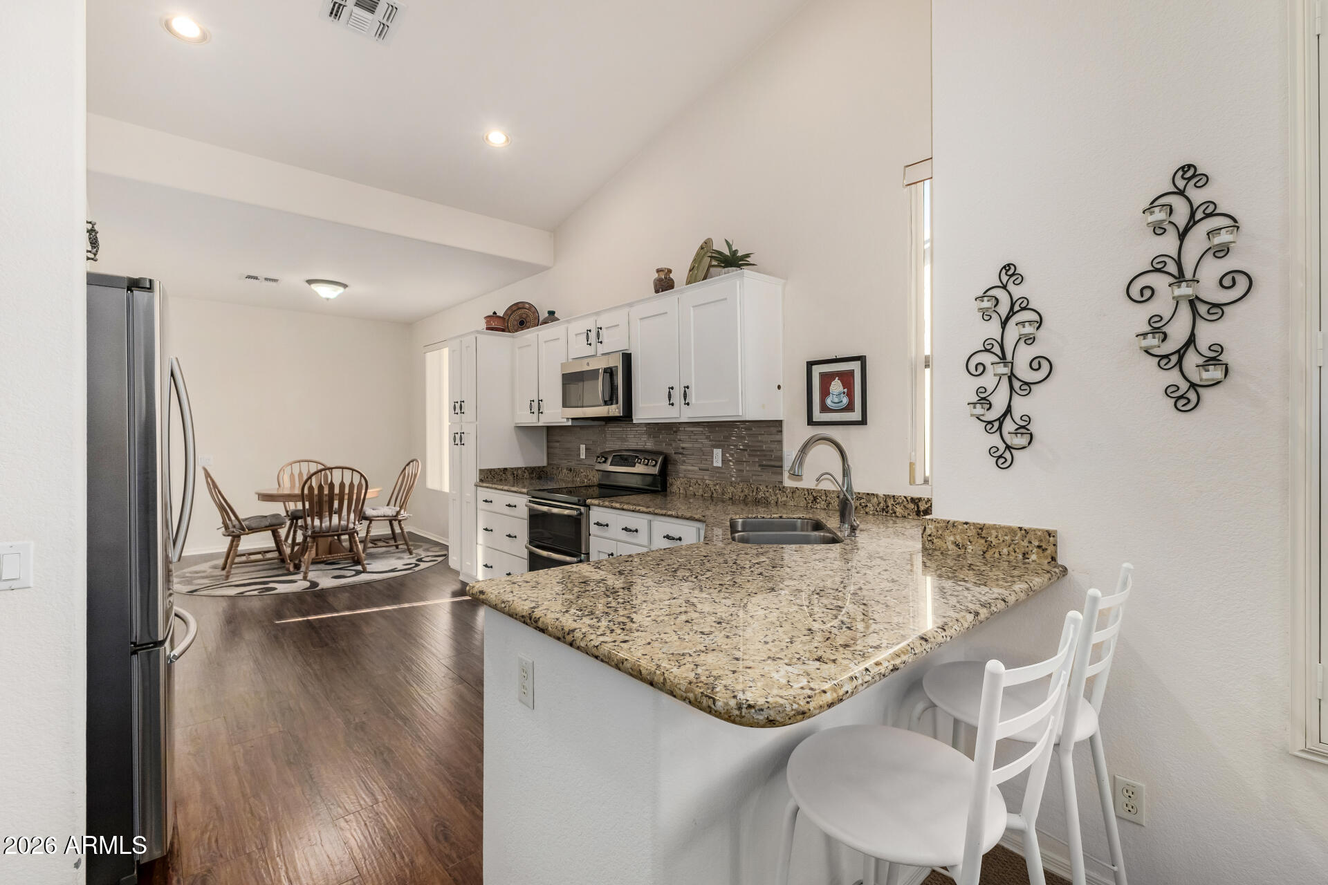 a kitchen with kitchen island granite countertop a sink cabinets and window