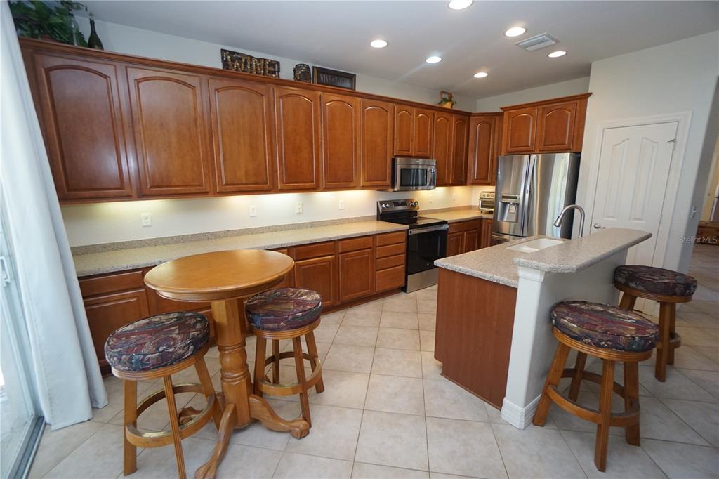 25554 Prada Drive Punta Gorda, FL 33955 - Photo 12 of 56 a kitchen with stainless steel appliances granite countertop a table chairs sink and cabinets