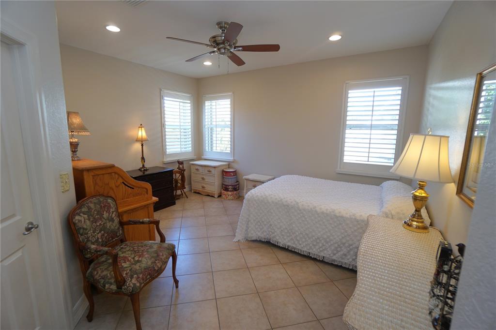 25554 Prada Drive Punta Gorda, FL 33955 - Photo 16 of 56 a spacious bedroom with a bed a chandelier and dresser