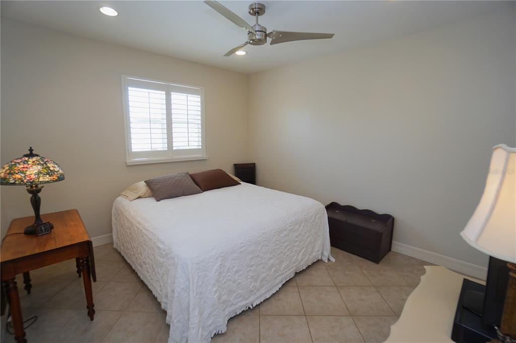 25554 Prada Drive Punta Gorda, FL 33955 - Photo 20 of 56 a bedroom with a bed and a chandelier