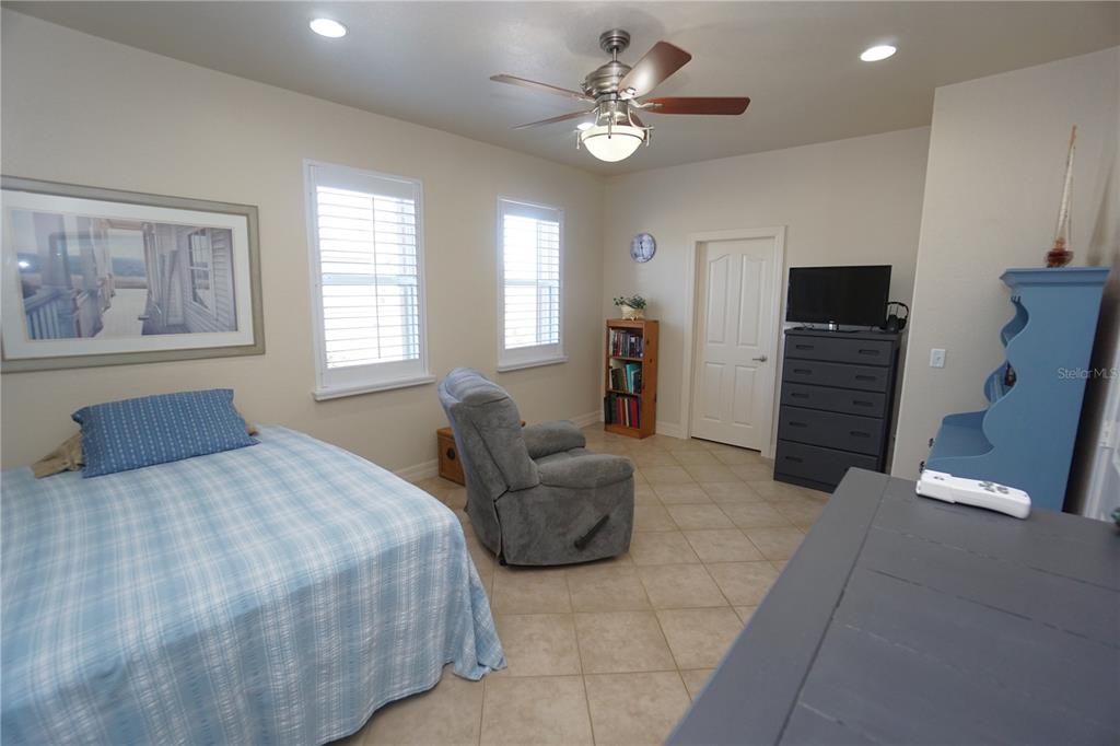 25554 Prada Drive Punta Gorda, FL 33955 - Photo 24 of 56 a spacious bedroom with a bed and a chandelier