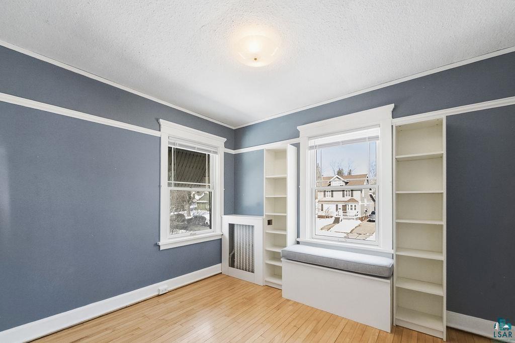 4220 McCulloch Street Duluth, MN 55804 - Photo 14 of 27 Unfurnished bedroom with light wood-style floors, a textured ceiling, and crown molding