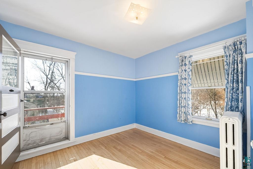 4220 McCulloch Street Duluth, MN 55804 - Photo 15 of 27 Spare room featuring radiator heating unit and light wood-style floors