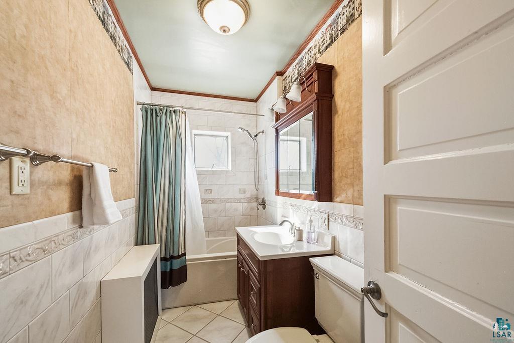 4220 McCulloch Street Duluth, MN 55804 - Photo 20 of 27 Bathroom with vanity, shower / bath combo, tile walls, ornamental molding, and light tile patterned floors