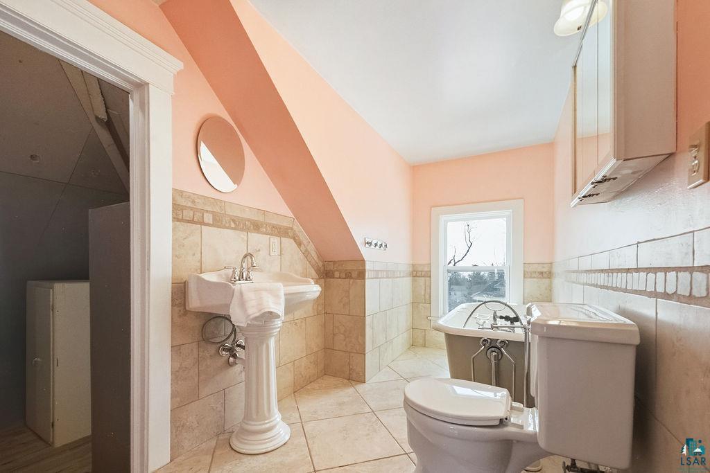 4220 McCulloch Street Duluth, MN 55804 - Photo 24 of 27 Half bath featuring a wainscoted wall, tile walls, and light tile patterned floors