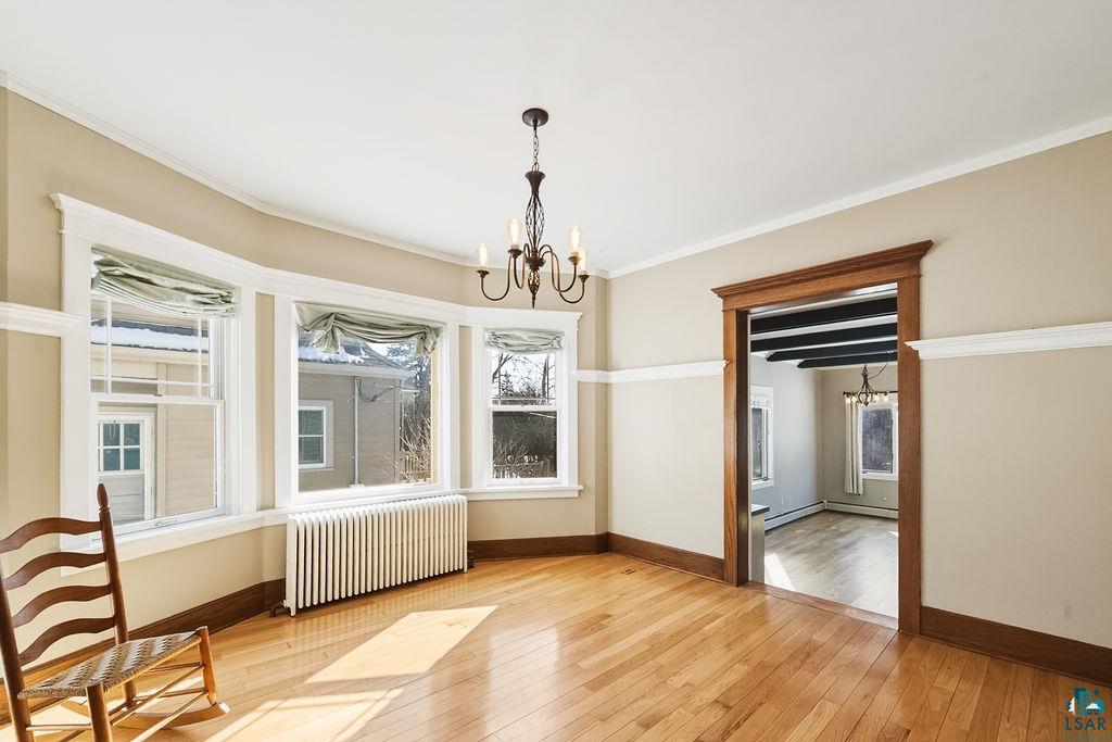 4220 McCulloch Street Duluth, MN 55804 - Photo 4 of 27 Unfurnished dining area featuring hanging lights, radiator heating unit, light wood-type flooring, ornamental molding, and baseboard heating