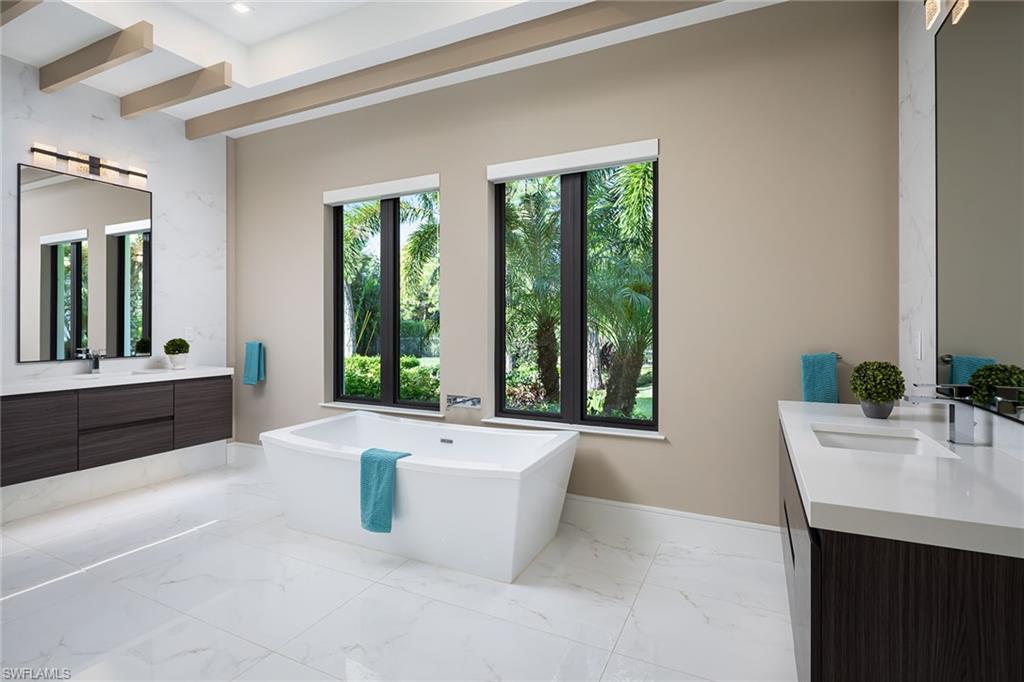 494 Gordonia Road Naples, FL 34108 - Photo 12 of 42 a bathroom with a tub a sink and mirror