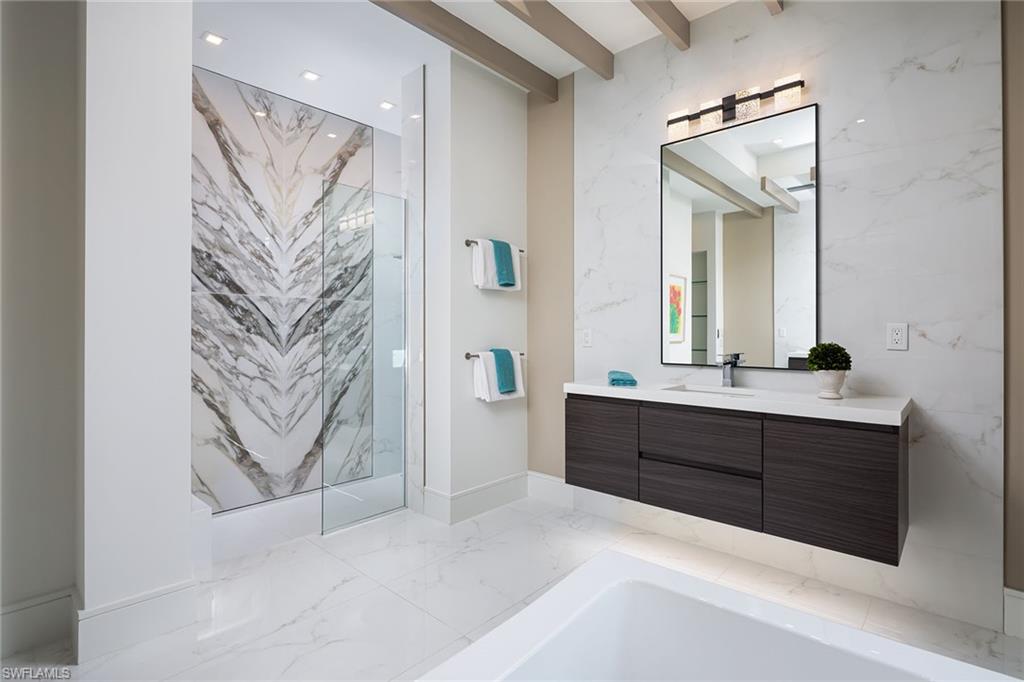 494 Gordonia Road Naples, FL 34108 - Photo 13 of 42 a spacious bathroom with a bathtub sink and mirror