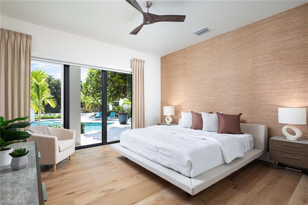 494 Gordonia Road Naples, FL 34108 - Photo 19 of 42 a bedroom with a large bed and a large window