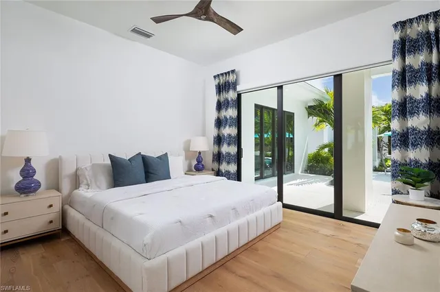 a large white bed sitting in a bedroom next to a window