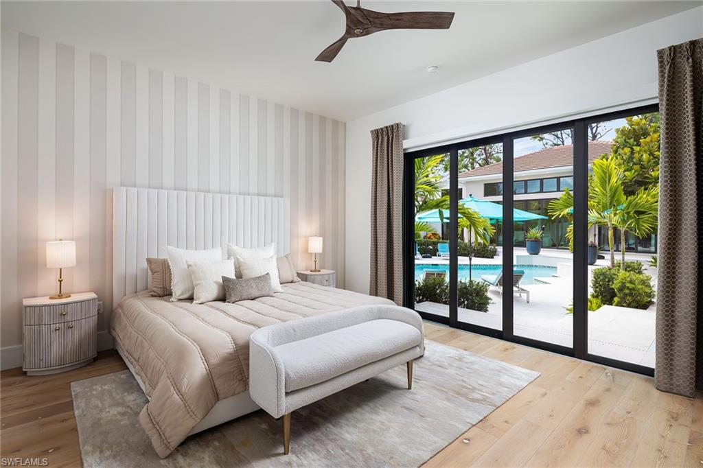 494 Gordonia Road Naples, FL 34108 - Photo 23 of 42 a bedroom with a large bed and a large window