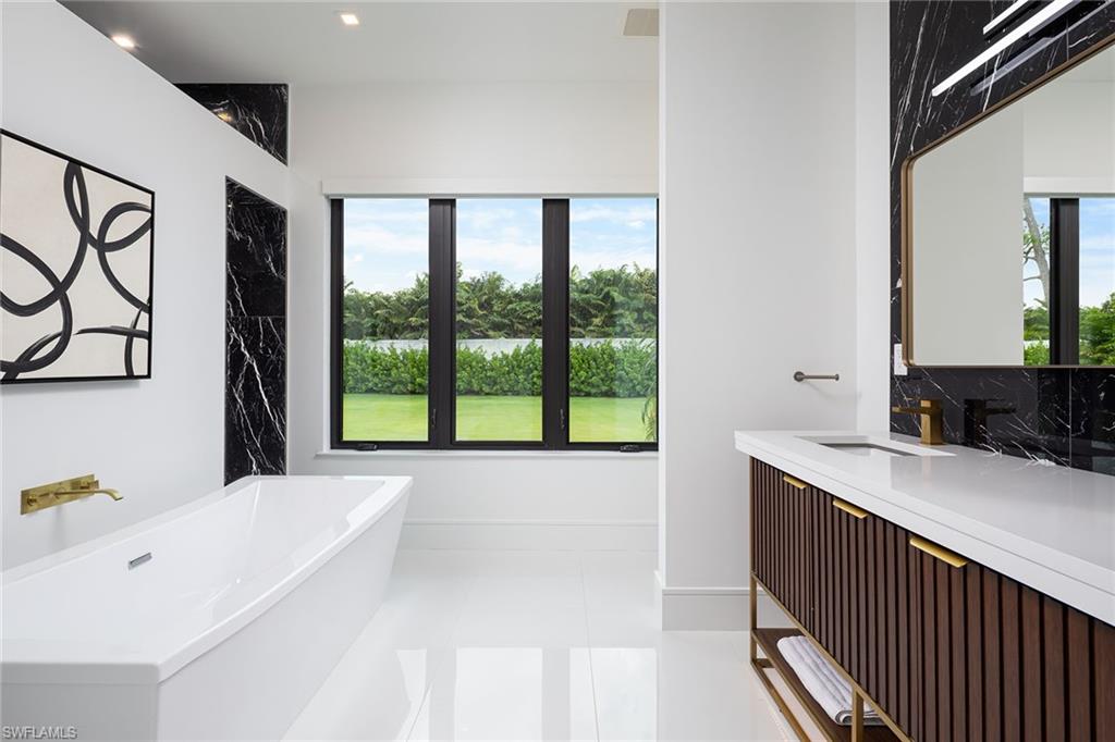 494 Gordonia Road Naples, FL 34108 - Photo 25 of 42 a bathroom with a bathtub and a sink