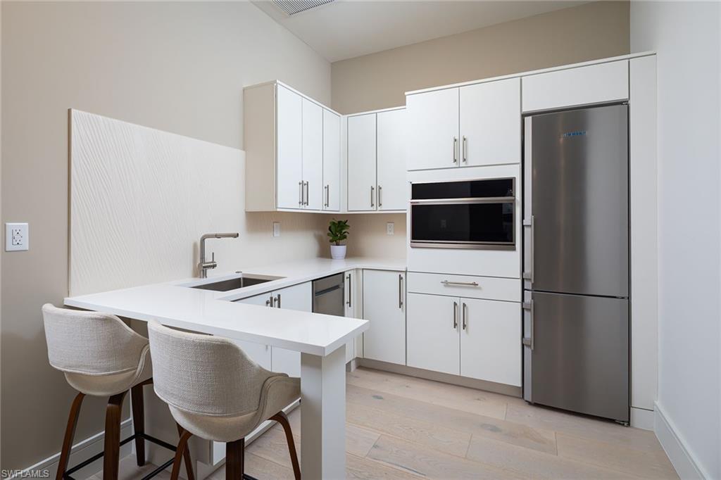 494 Gordonia Road Naples, FL 34108 - Photo 28 of 42 a kitchen with stainless steel appliances a stove a sink refrigerator and white cabinets
