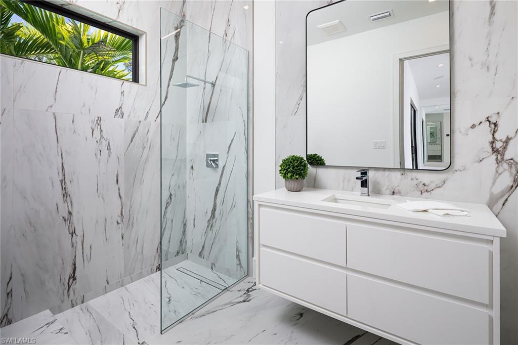 494 Gordonia Road Naples, FL 34108 - Photo 29 of 42 a bathroom with a double vanity sink and mirror