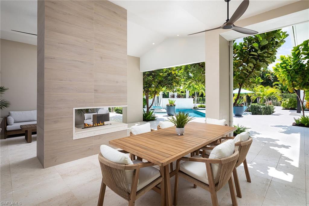 494 Gordonia Road Naples, FL 34108 - Photo 30 of 42 a outdoor dining space with furniture and a fireplace