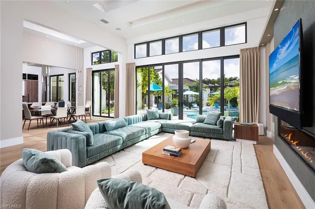 a living room with furniture large windows and a flat screen tv
